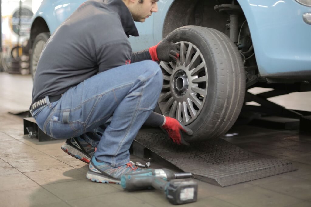 A mechanic changing a car tyre in a garage workshop