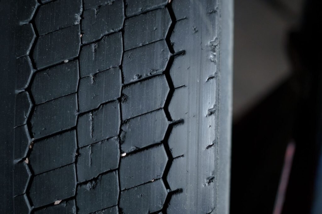 A close-up of a worn car tyre tread showing its grooves and pattern
