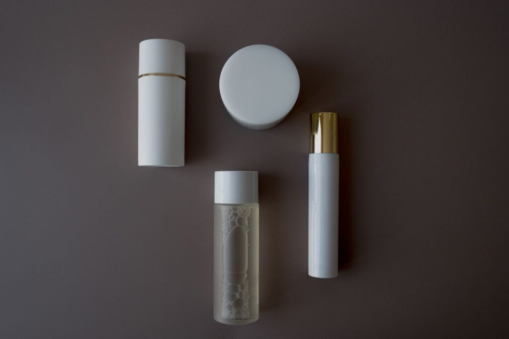 A few unbranded skincare bottles and jars arranged on a dark surface